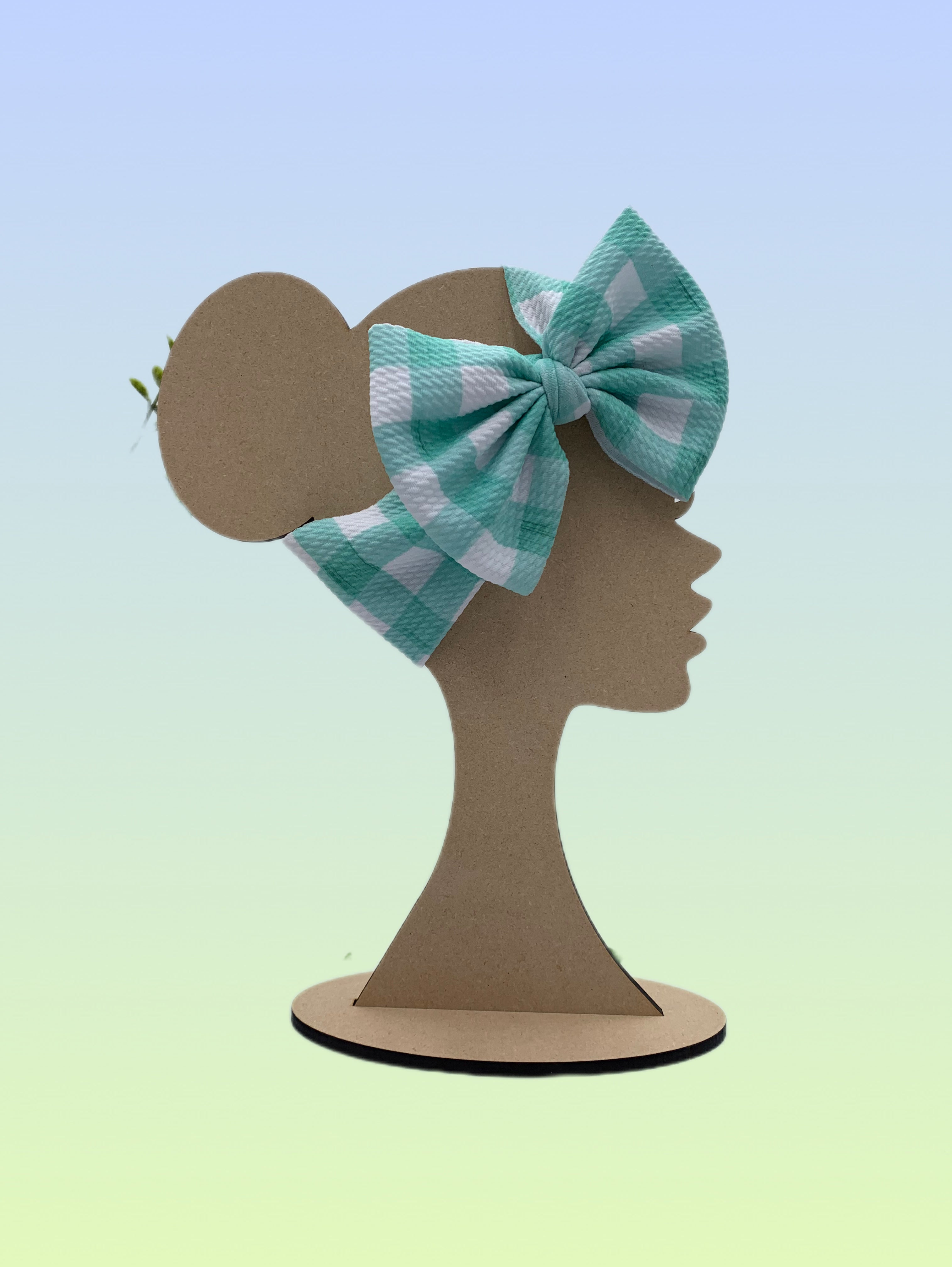 Handmade mint green and white gingham big bow headband shown on a display stand.