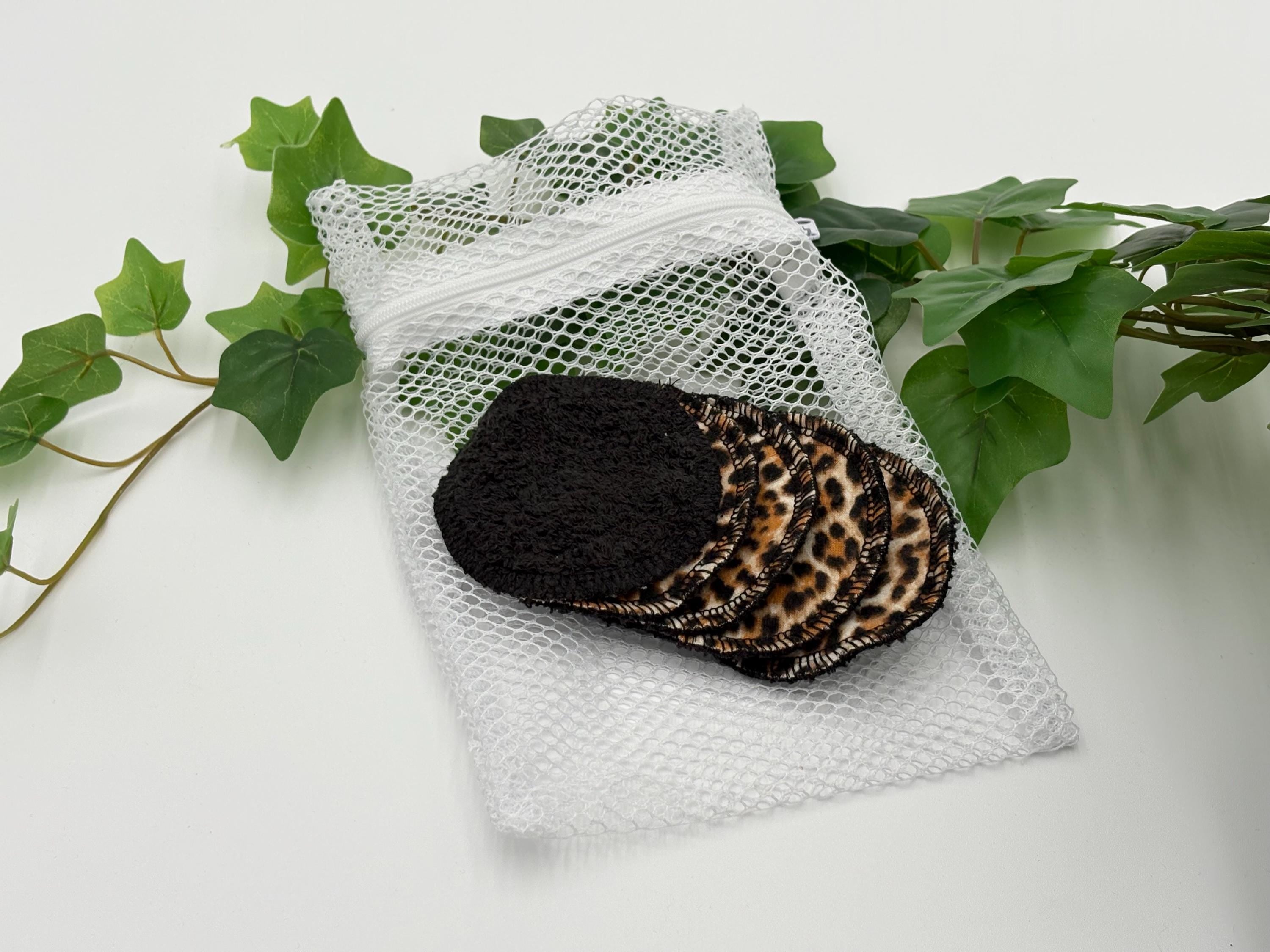 Five Reusable pads with leopard print pattern on a white mesh bag with green leaves in the background