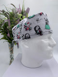 Mannequin head wearing a nightmare before christmas scrub cap with a decorative plant in the background.