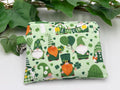 Small coin purse keychain with green st. patrick's day gnomes pattern on a white background with green leaves