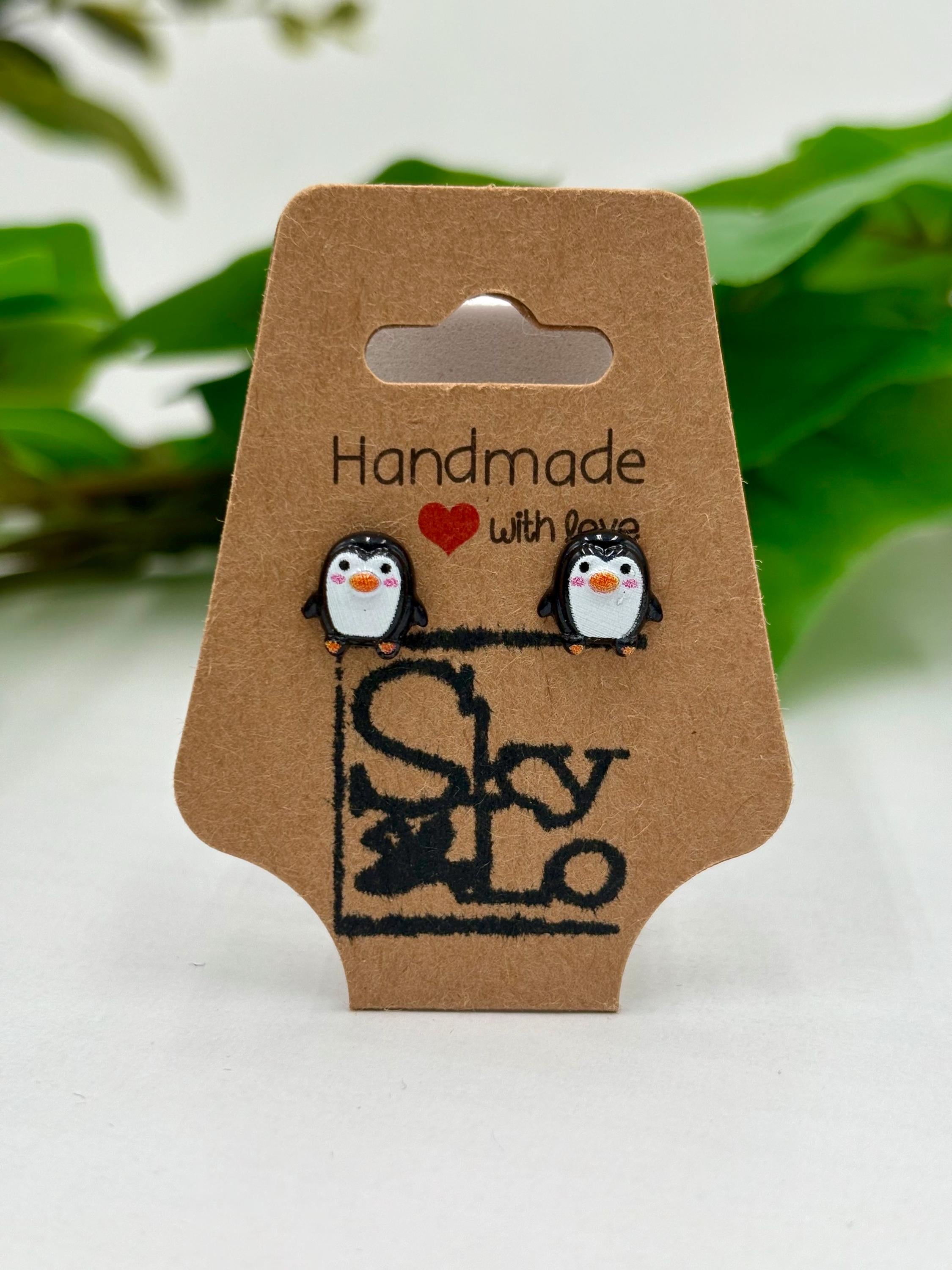 Pair of penguin earrings on a 'Handmade with Love' card with a brand logo.