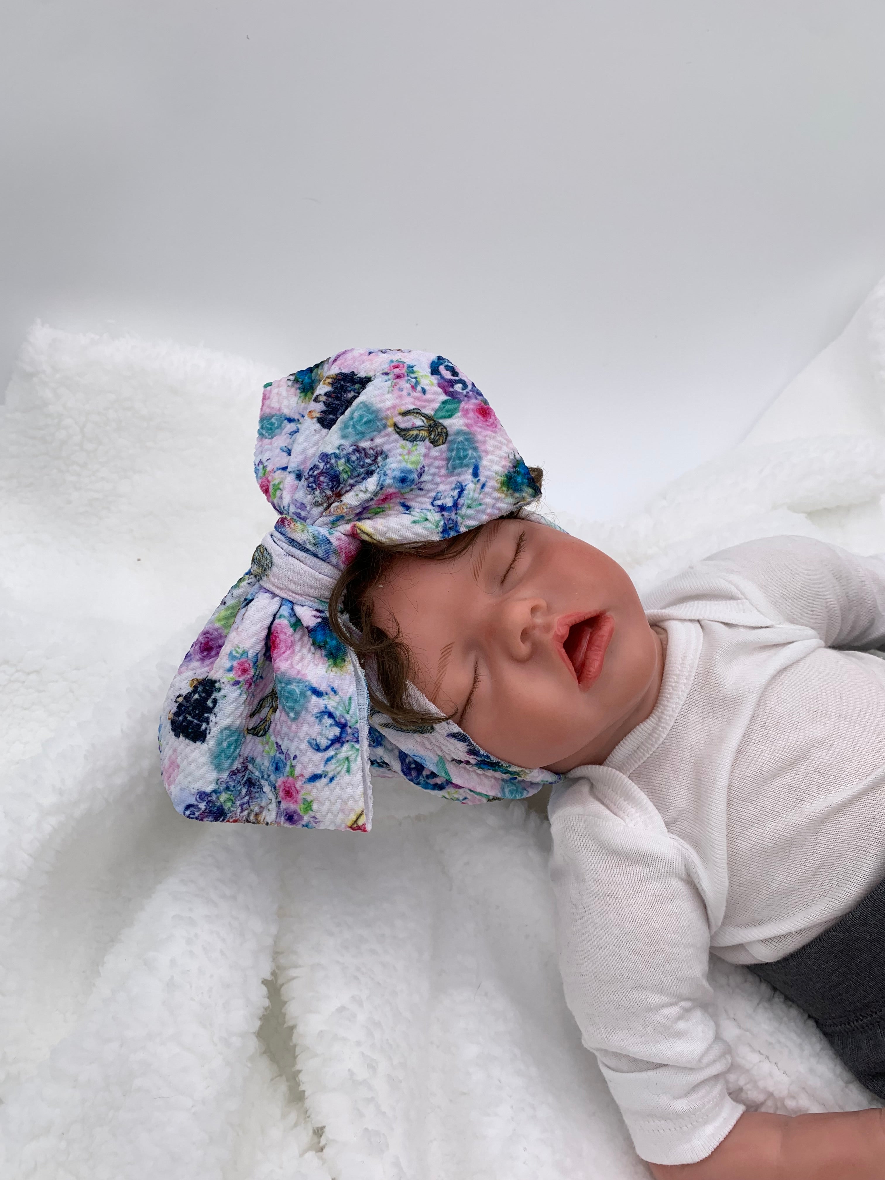 baby doll wearing a Fantasy wizard themed big bow headband on a white background