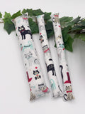 Three cylindrical catnip toys with cat illustrations on a white background with green leaves.