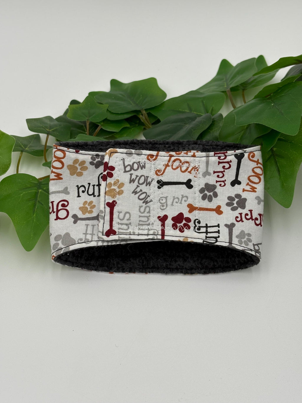 patterned belly band on a white background next to green plant
