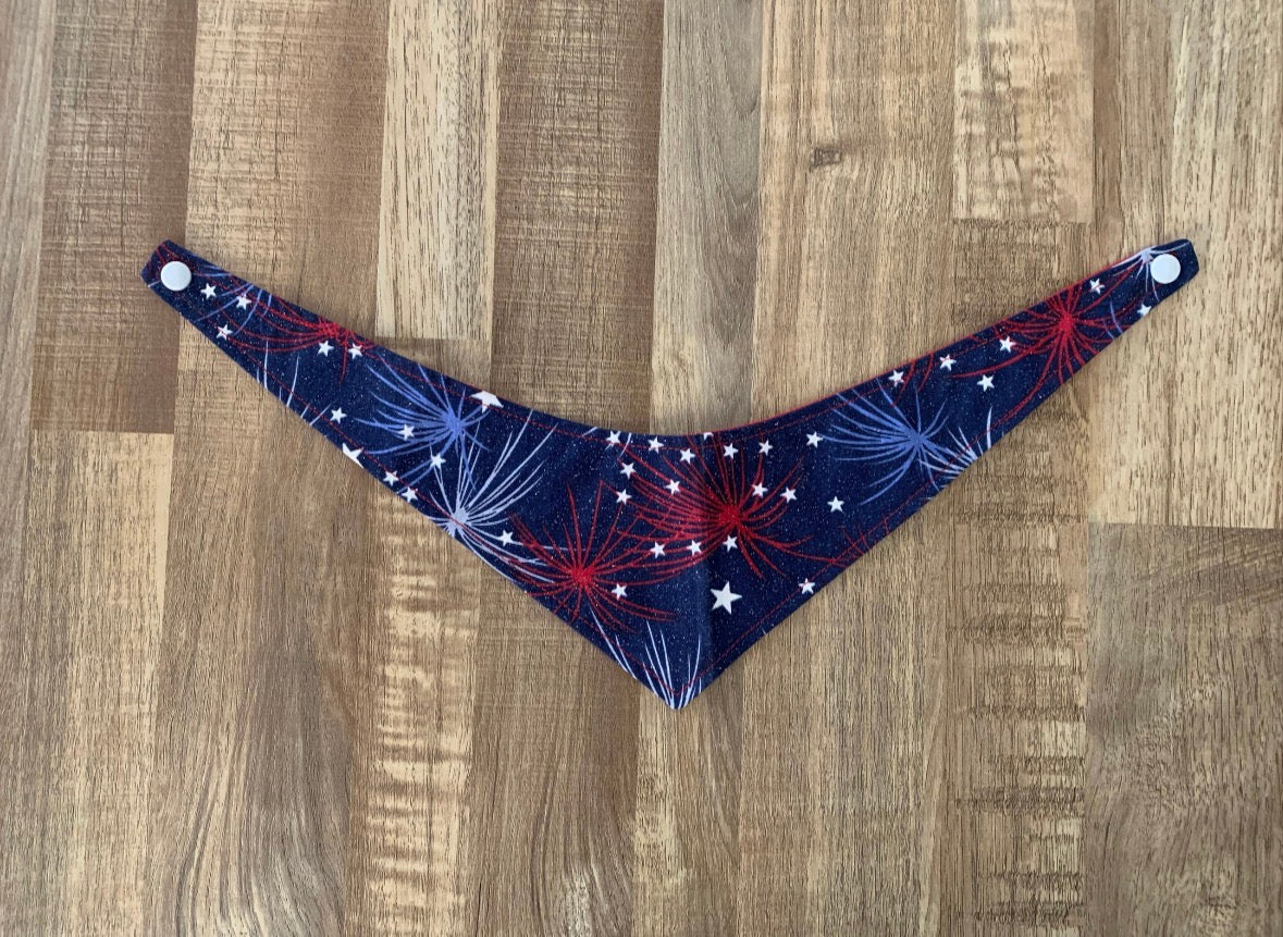 Blue with light blue and red fireworks with white stars 4th of july themed pet bandana on a wooden floor