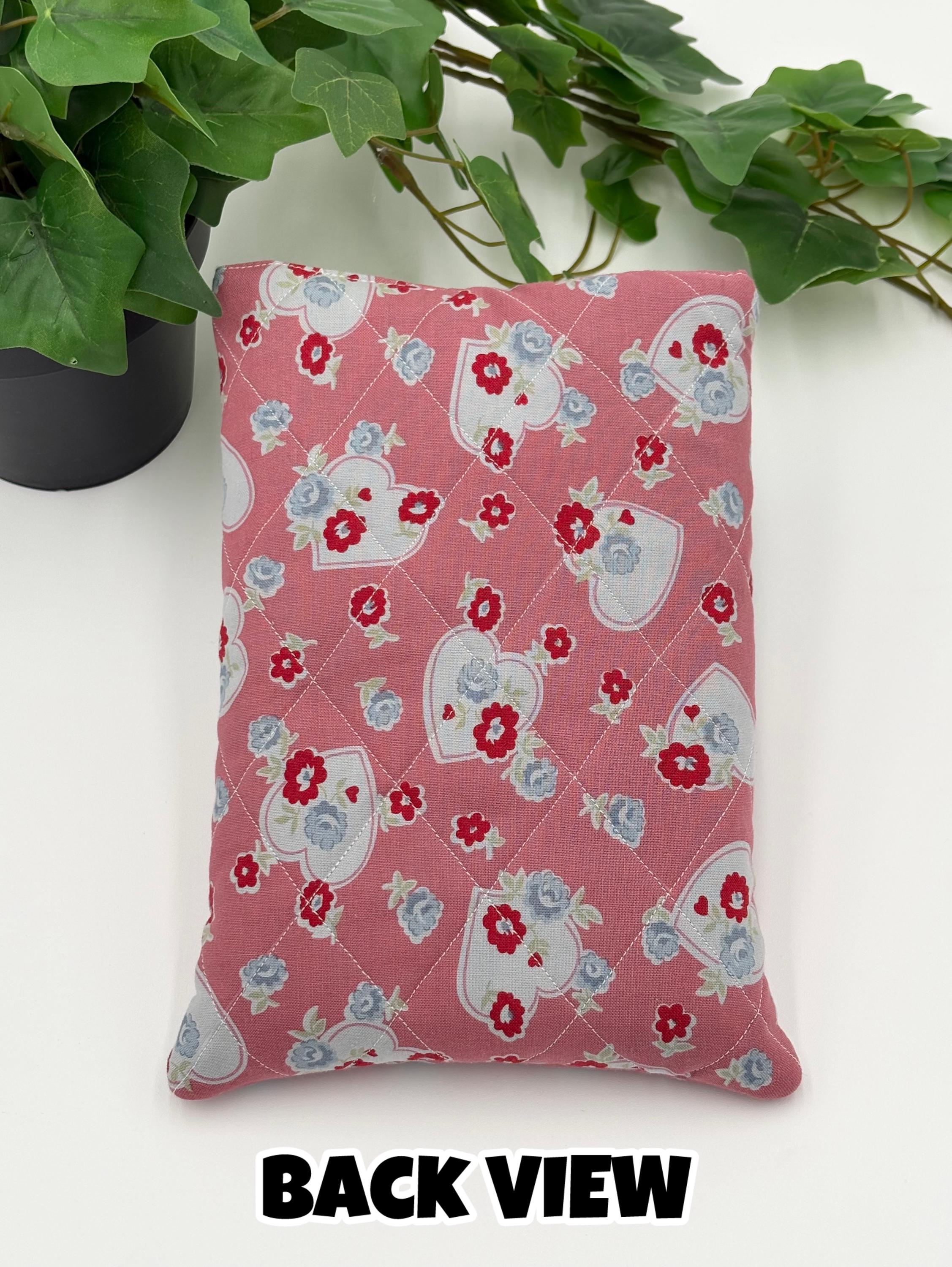 Floral and heart patterned book sleeve with pens and book on a white background With the text “back view”