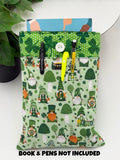 Green saint Patrick’s day gnomes and clovers patterned book sleeve with pens and book on a white surface and text “book and pens not included”