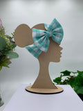 Blue checkered bow on a mannequin head with a white background