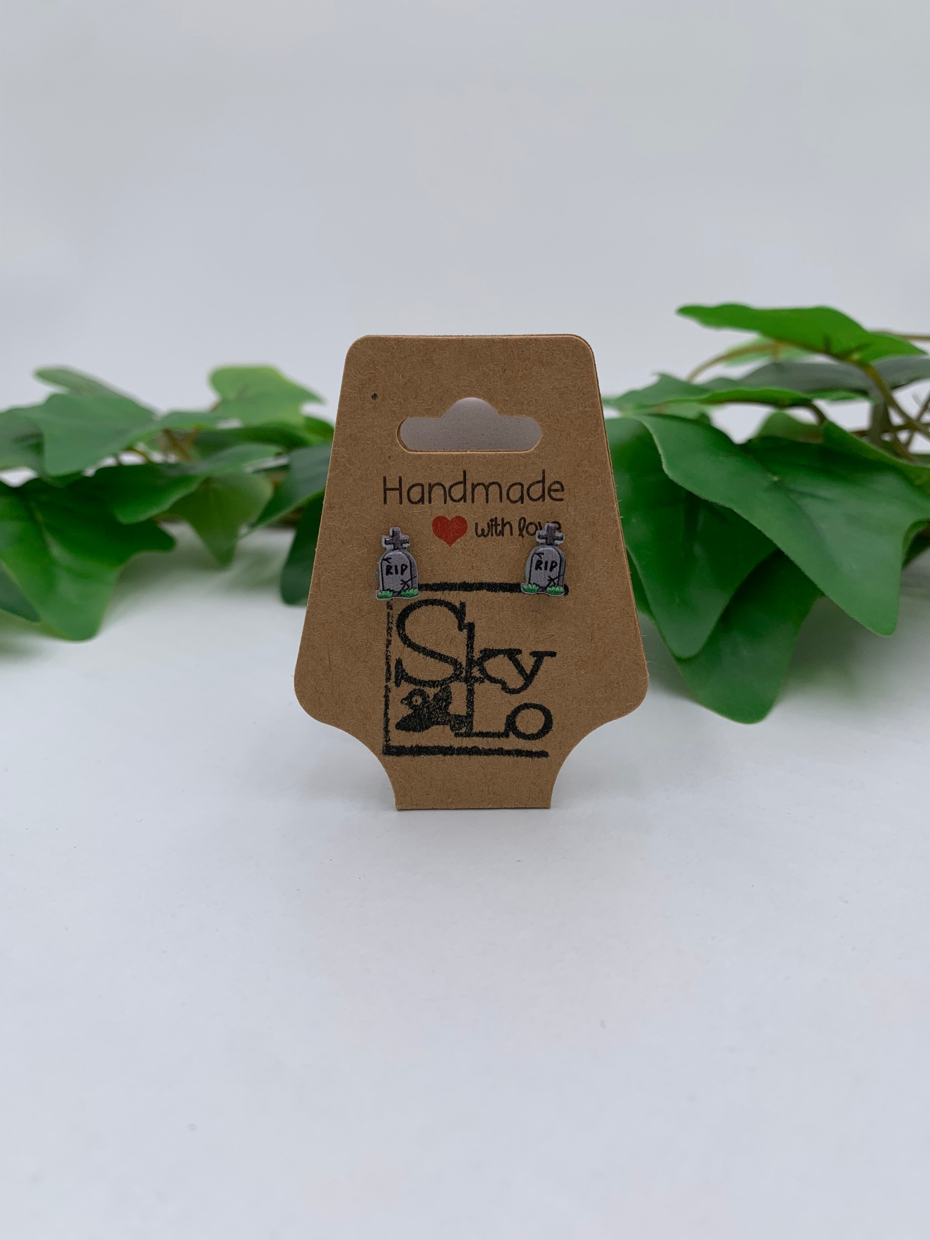 Pair of tombstone earrings on a 'Handmade with Love' branded card with green leaves in the background