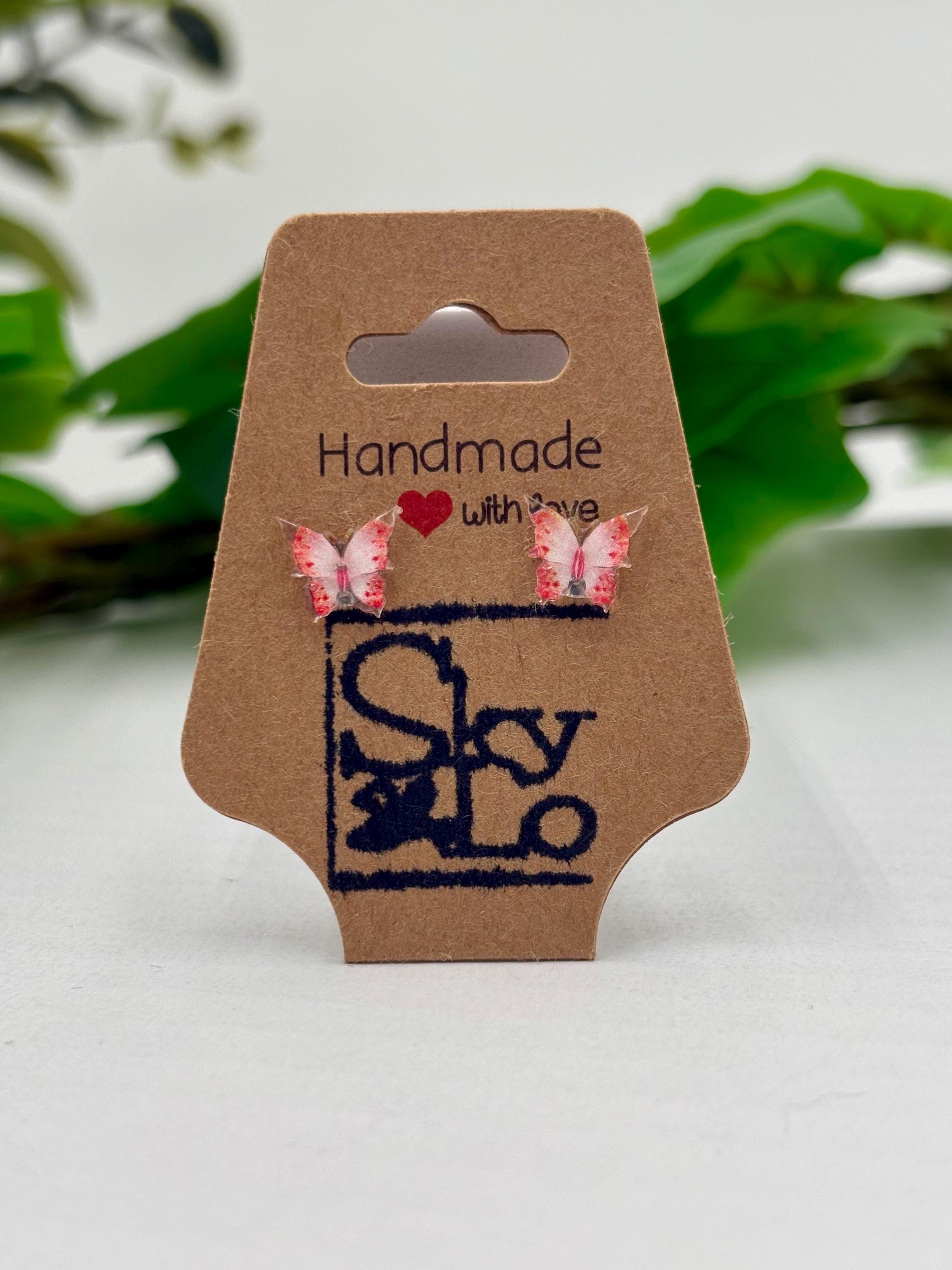Pink Butterfly earrings on a 'Handmade with Love' branded card with a green leafy background.