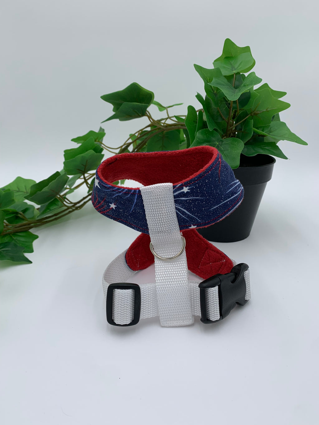 back view of a blue 4th of July harness on a white background with a potted green plant