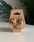 Leopard print earrings on a 'Handmade with Love' card with a plant in the background