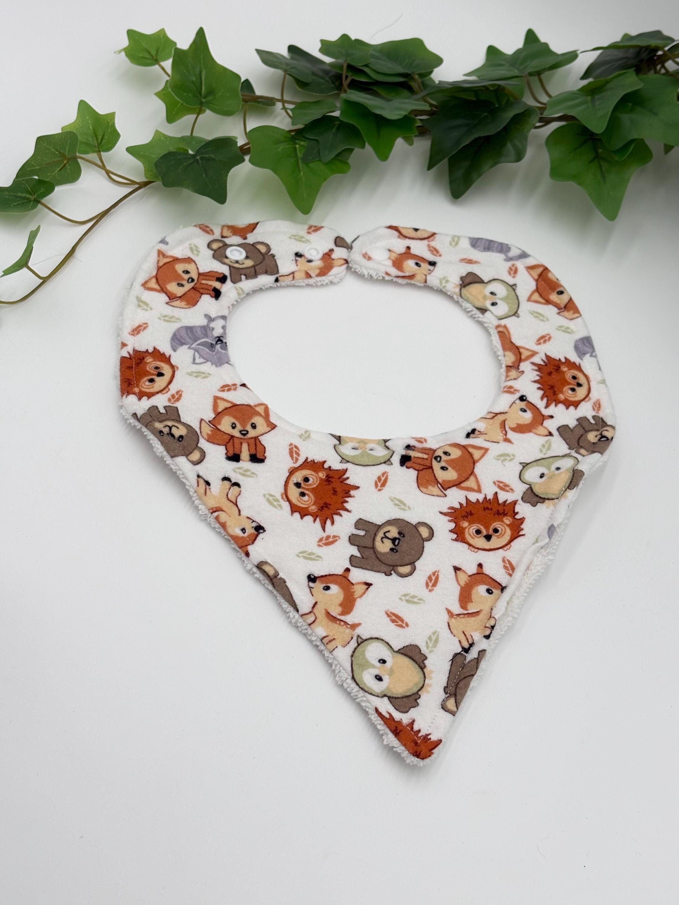 Baby bib with animal pattern on a white background with green leaves