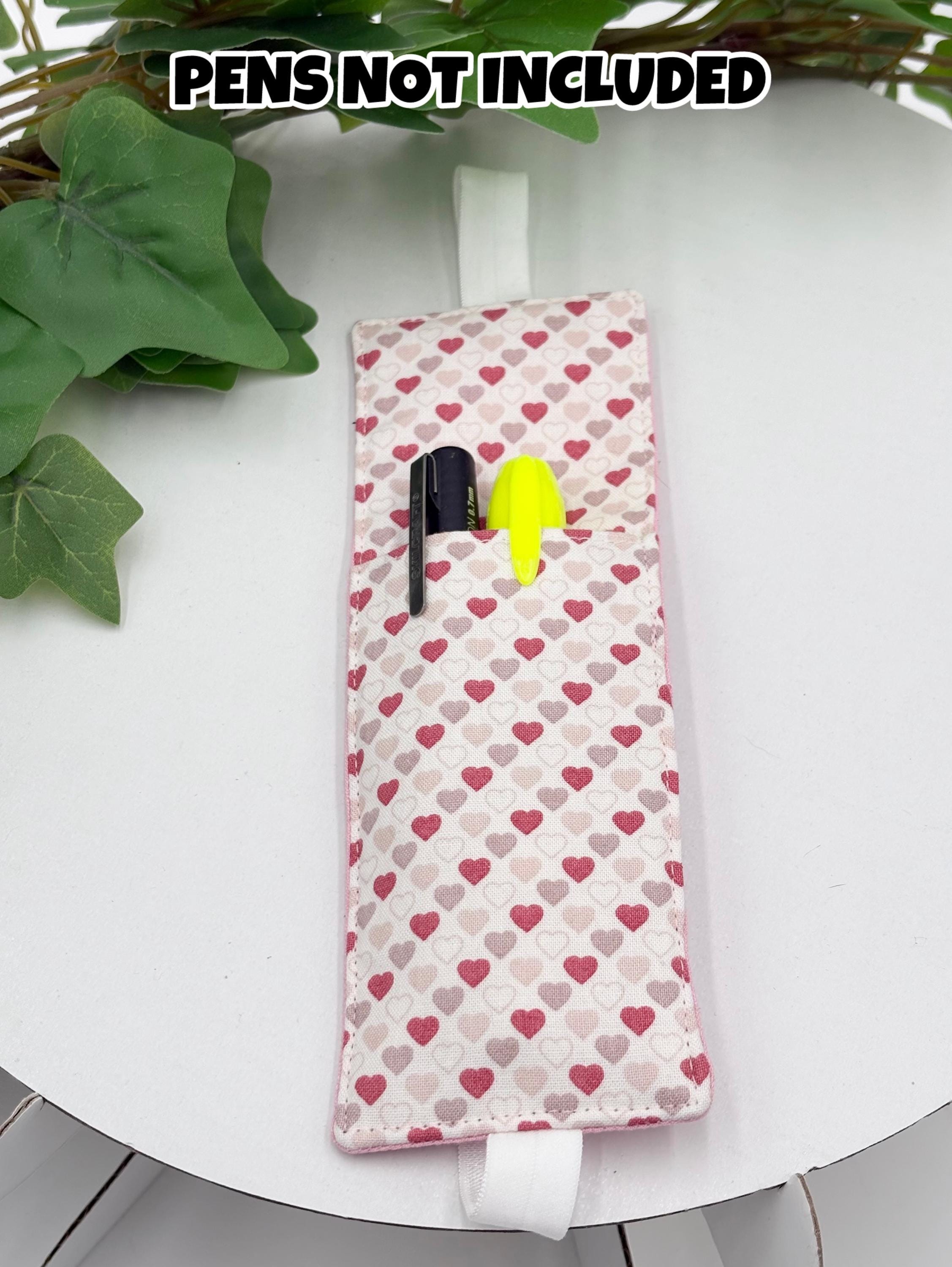 Pink Heart patterned pen holder on a white surface with text 'PENS NOT INCLUDED'.