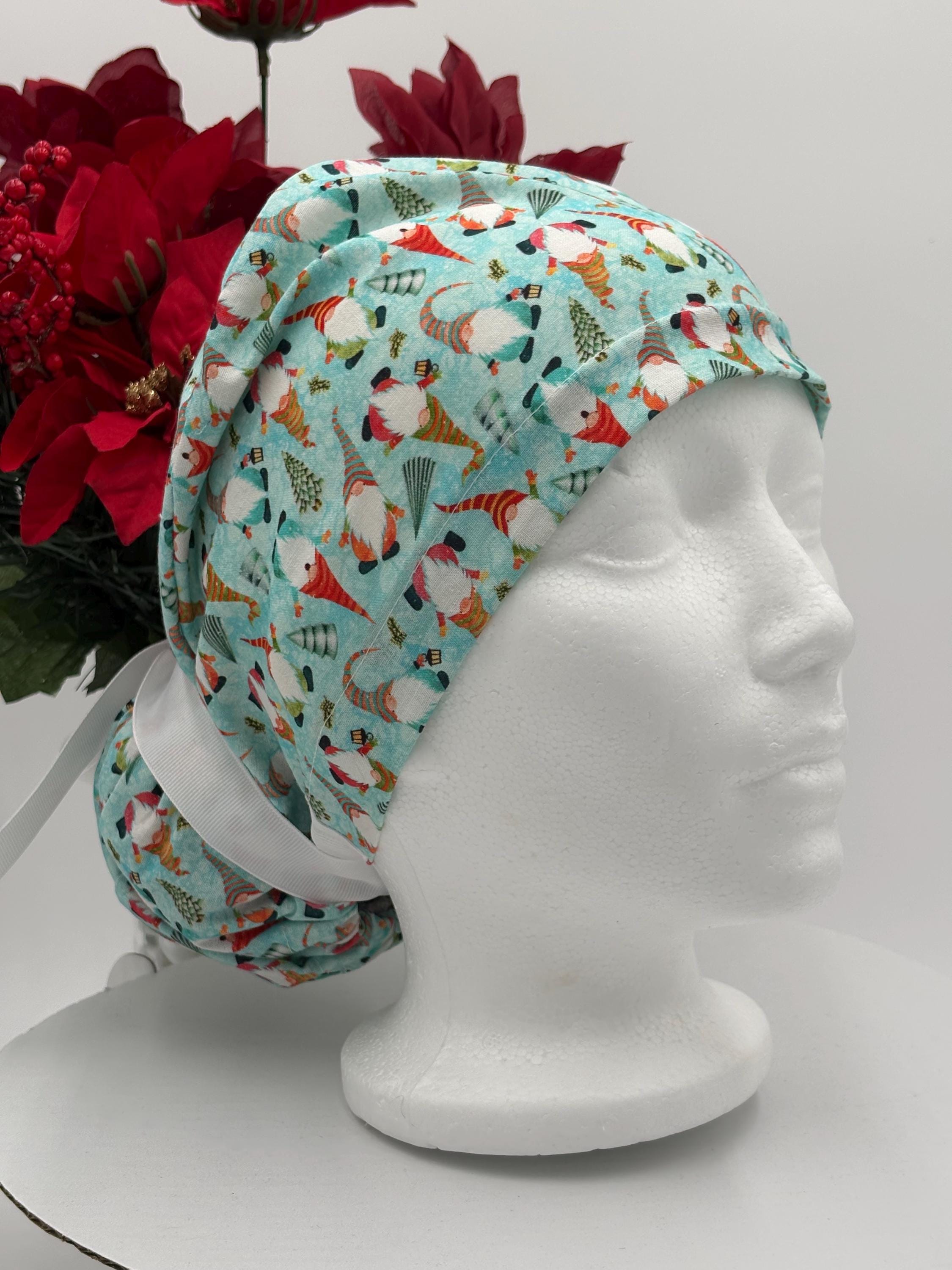 Gnomes scrub cap on a mannequin head against a white background and red flowers in the background