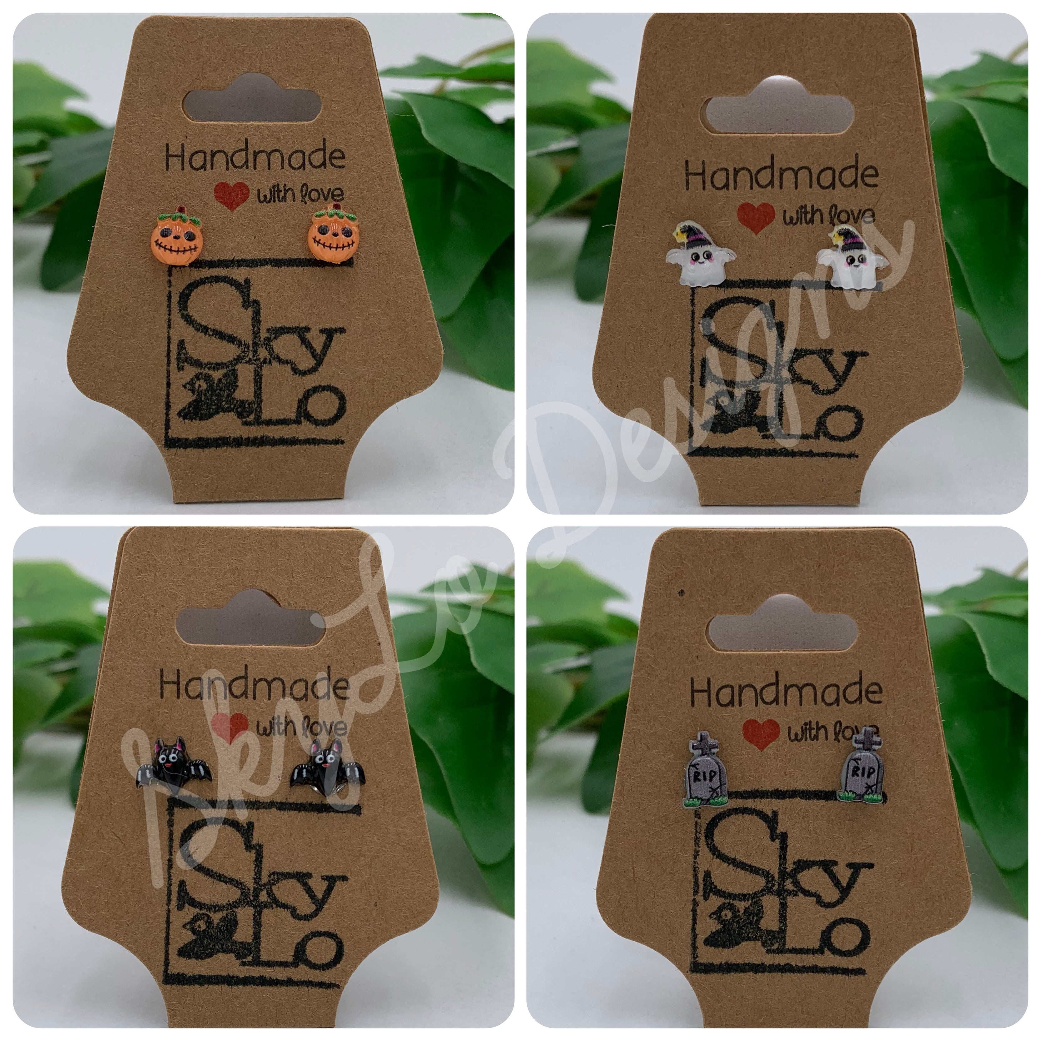 Set of four pairs of Halloween themed earrings on display cards with 'SkyLo' branding, against a green leafy background.