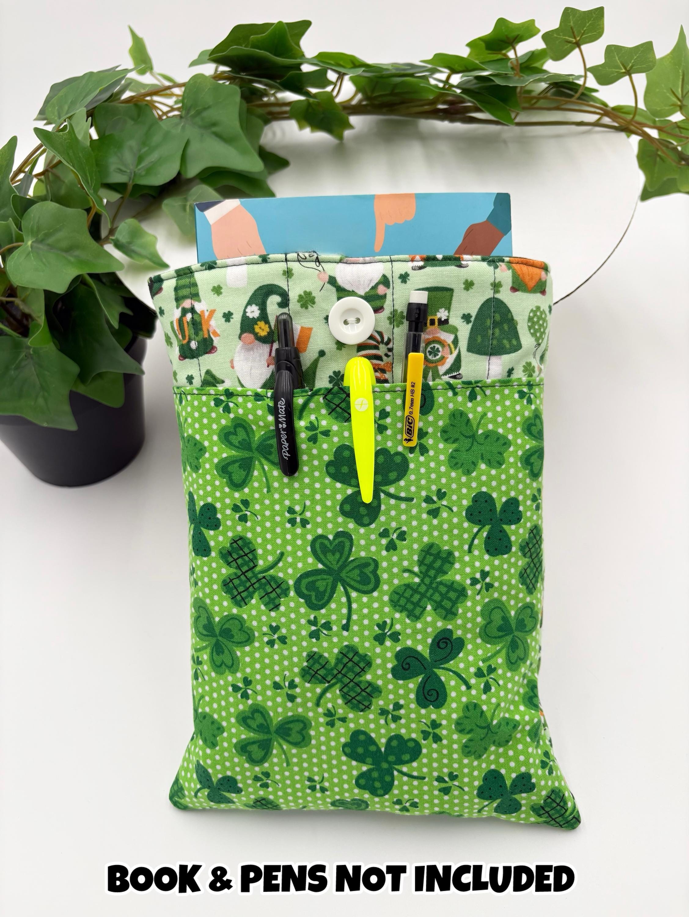 Green saint Patrick’s day gnomes and shamrocks patterned book sleeve with pens and book on a white surface and text “book and pens not included”