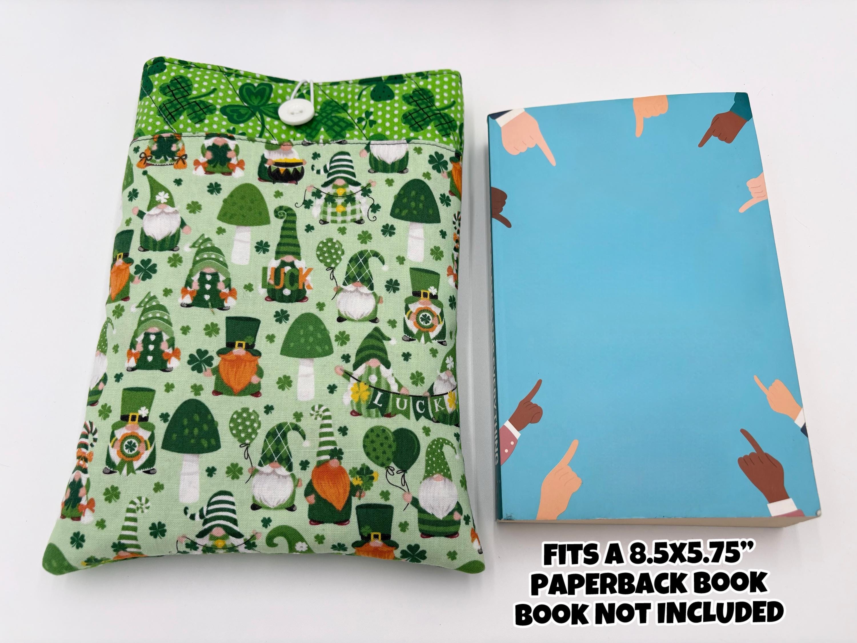 Green saint Patrick’s day gnomes and clovers patterned book sleeve with book on a white surface and text “fits a 8.5” x 5.75” paperback book, book not included”