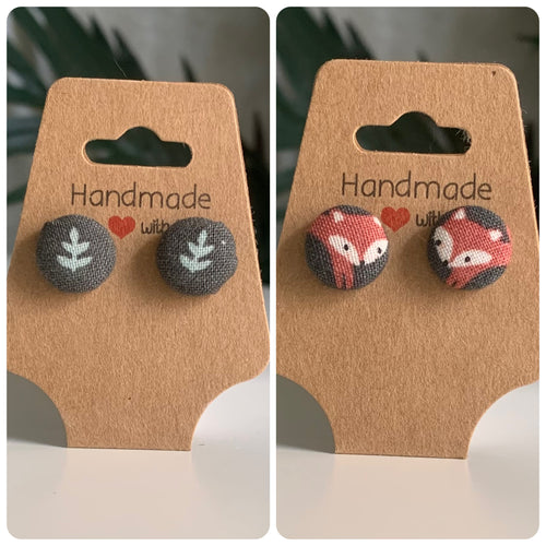 Two pairs of handmade earrings, a green background with a leaf in it and a green background with a fox on it, on brown card backs with 'Handmade with Love' text.
