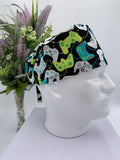 Colorful game controller scrub cap on a mannequin head with a bouquet of flowers in the background
