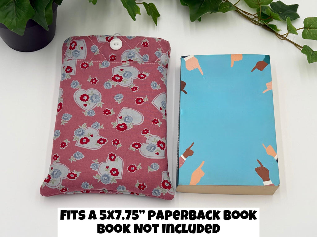 Pink Floral and heart patterned book sleeve and book on a white background with text “fits a 5” x 7” paperback book, book not included”
