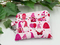 Small coin purse keychain with Valentine-themed gnomes and hearts pattern on a white background with green leaves