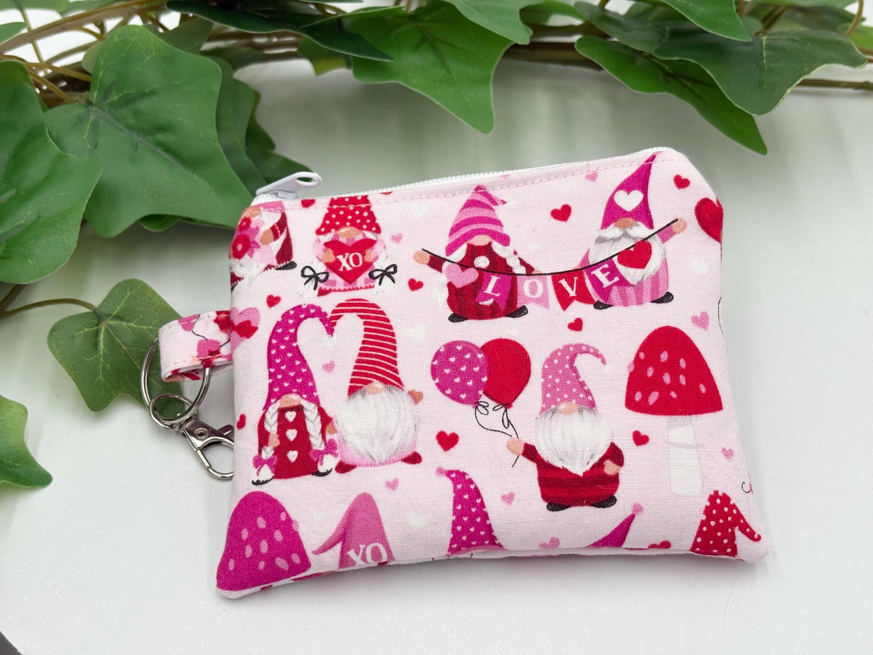 Small coin purse keychain with Valentine-themed gnomes and hearts pattern on a white background with green leaves
