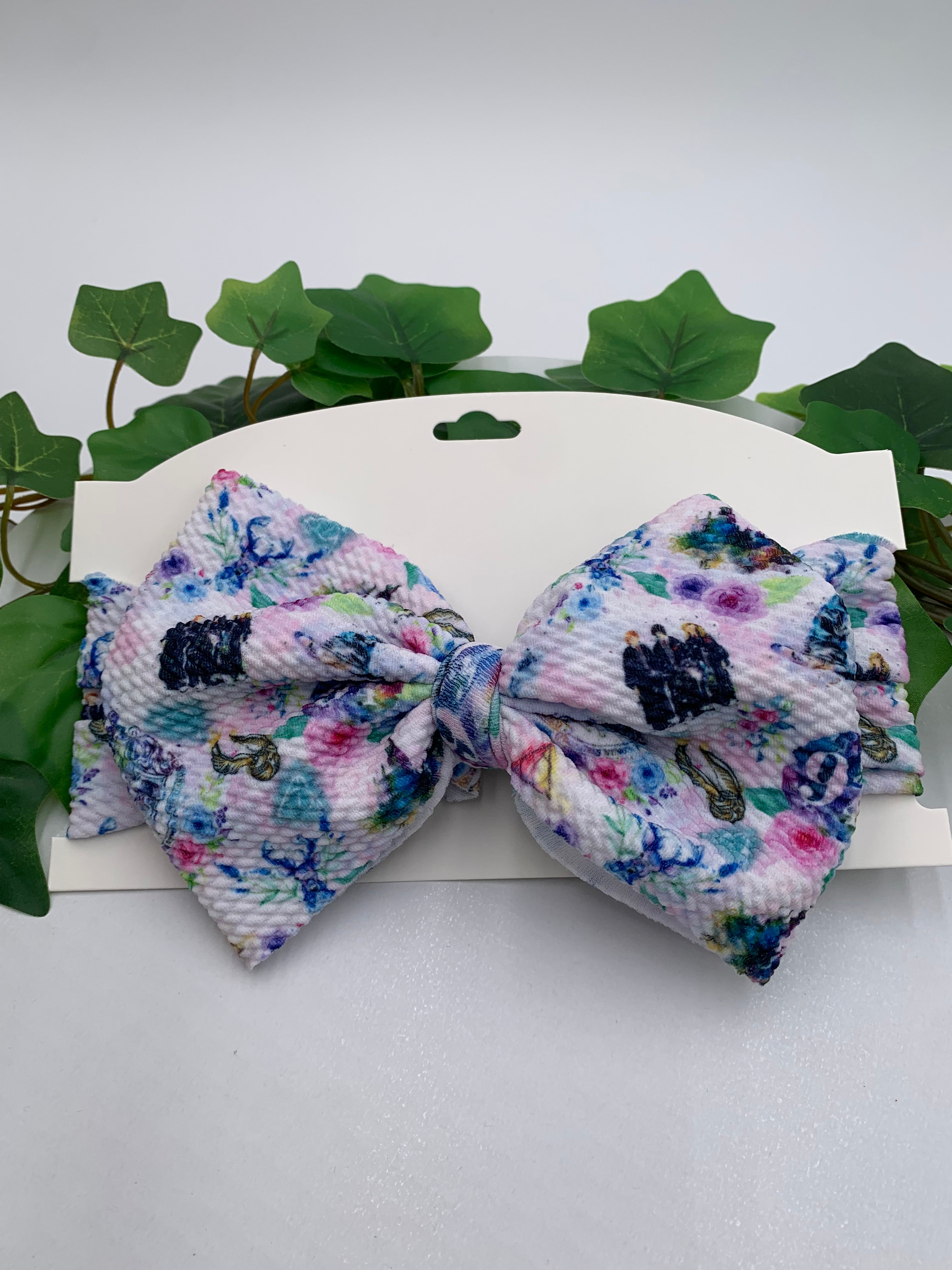Fantasy wizard themed big bow headband on a white card with a white background and greenery 