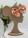 Autumn gnomes themed big bow nylon headband on a mannequin head with a white background and greenery 