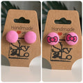 Pair of pink earrings with a pair of pink earrings with bow design on brown 'Handmade with Love' card.