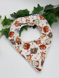 Baby bib with animal pattern on a white background with green leaves
