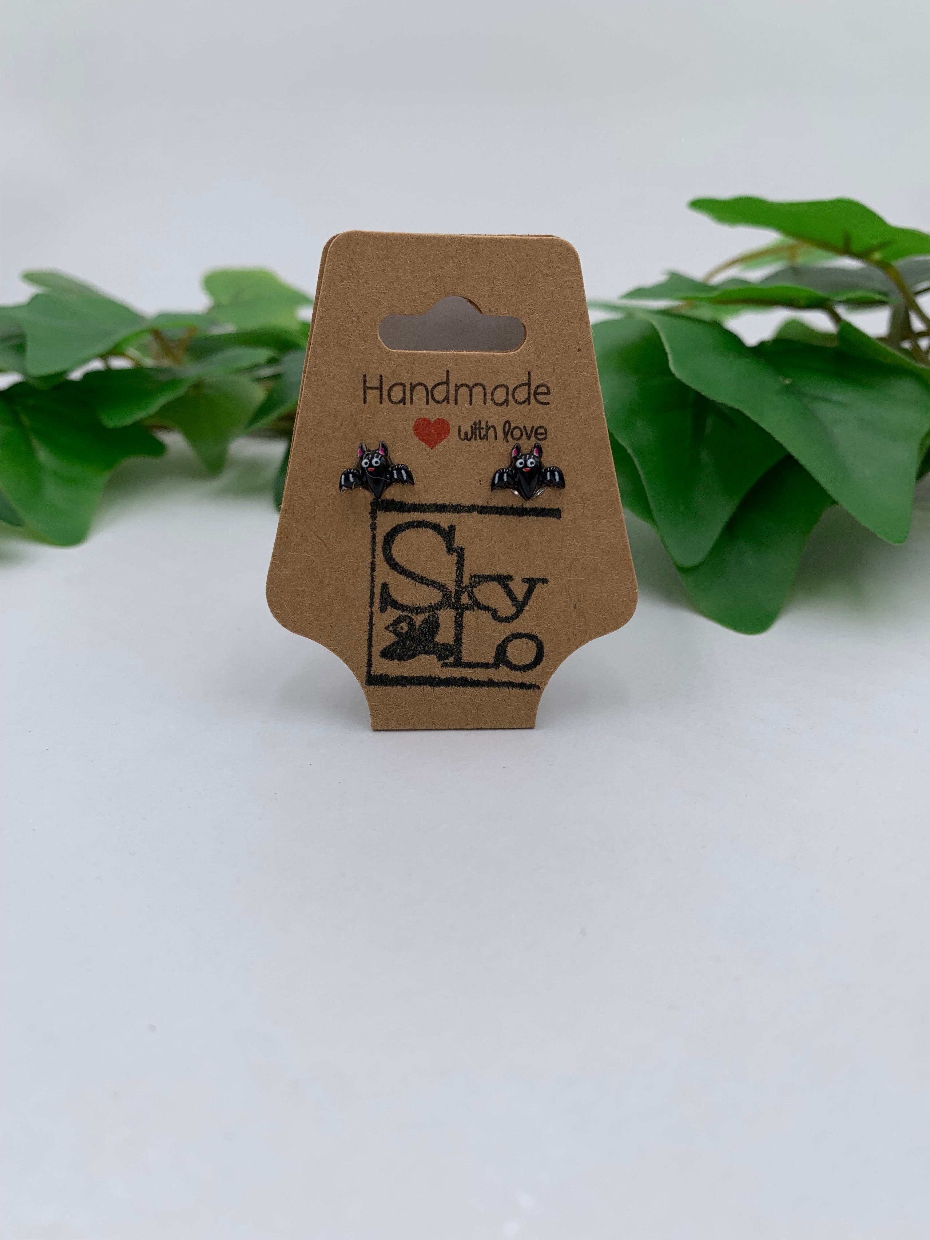 Pair of Bat earrings on a 'Handmade with Love' branded card with green leaves in the background