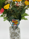 Bouquet of flowers with a comic book style with text "Best teacher ever" badge holder in a clear vase on a white background