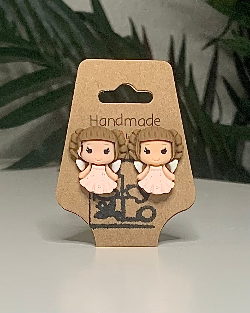 Faerie shaped earrings with a Kraft branded label on a neutral background with a green plant. 