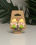 Faerie shaped earrings with a Kraft branded label on a neutral background with a green plant. 