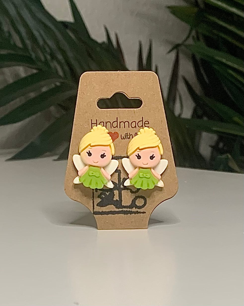 Faerie shaped earrings with a Kraft branded label on a neutral background with a green plant. 
