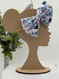 Nylon Headband with a decorative Wizards themed big bow on a mannequin head silhouette against a white background