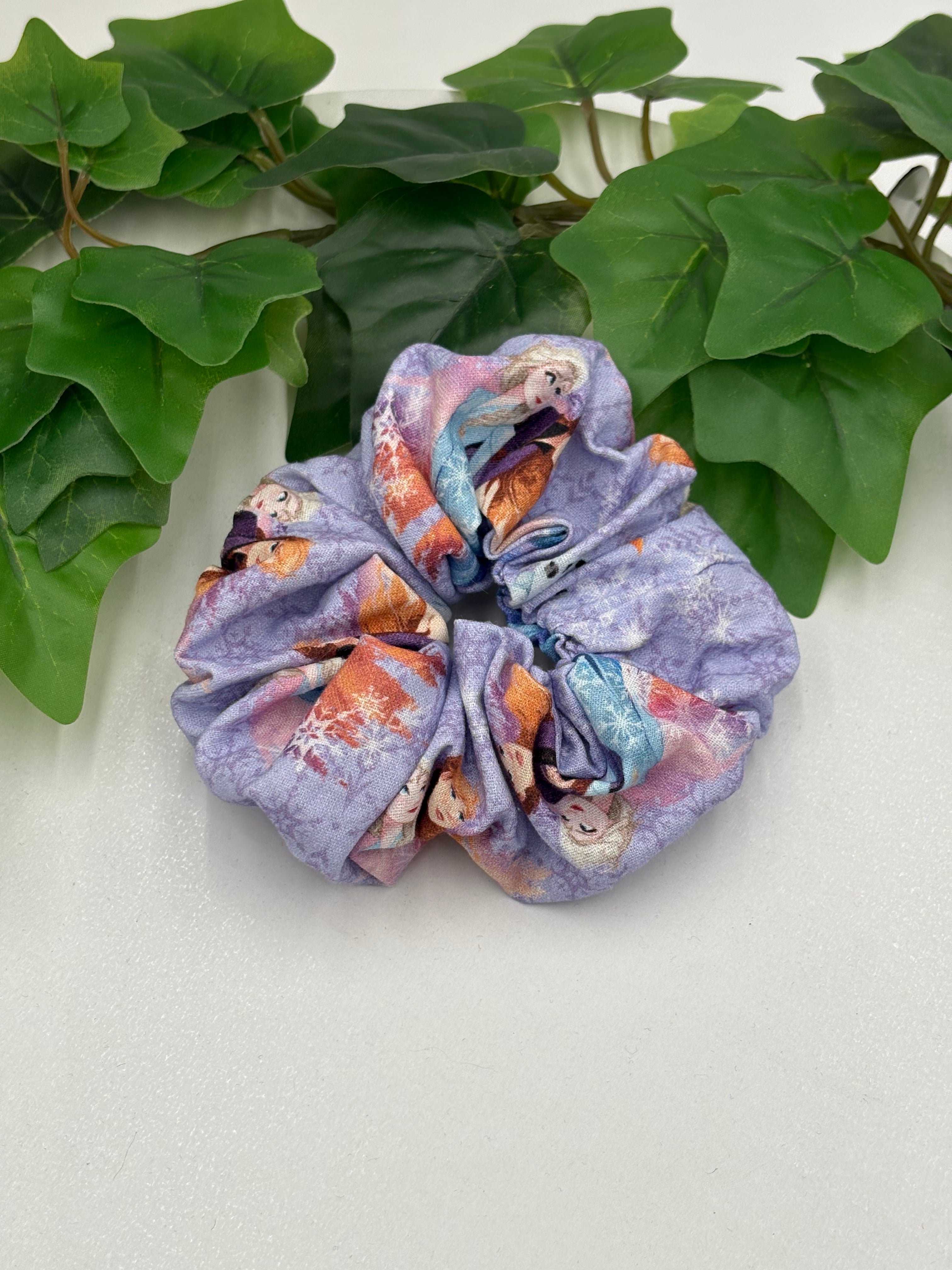 Multicolored scrunchie on a light background with green leaves