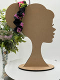 black floral themed scrunchie on a mannequin head with a white background and greenery 