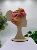 Spring flowers themed big bow headband on a mannequin head with a white background and greenery 