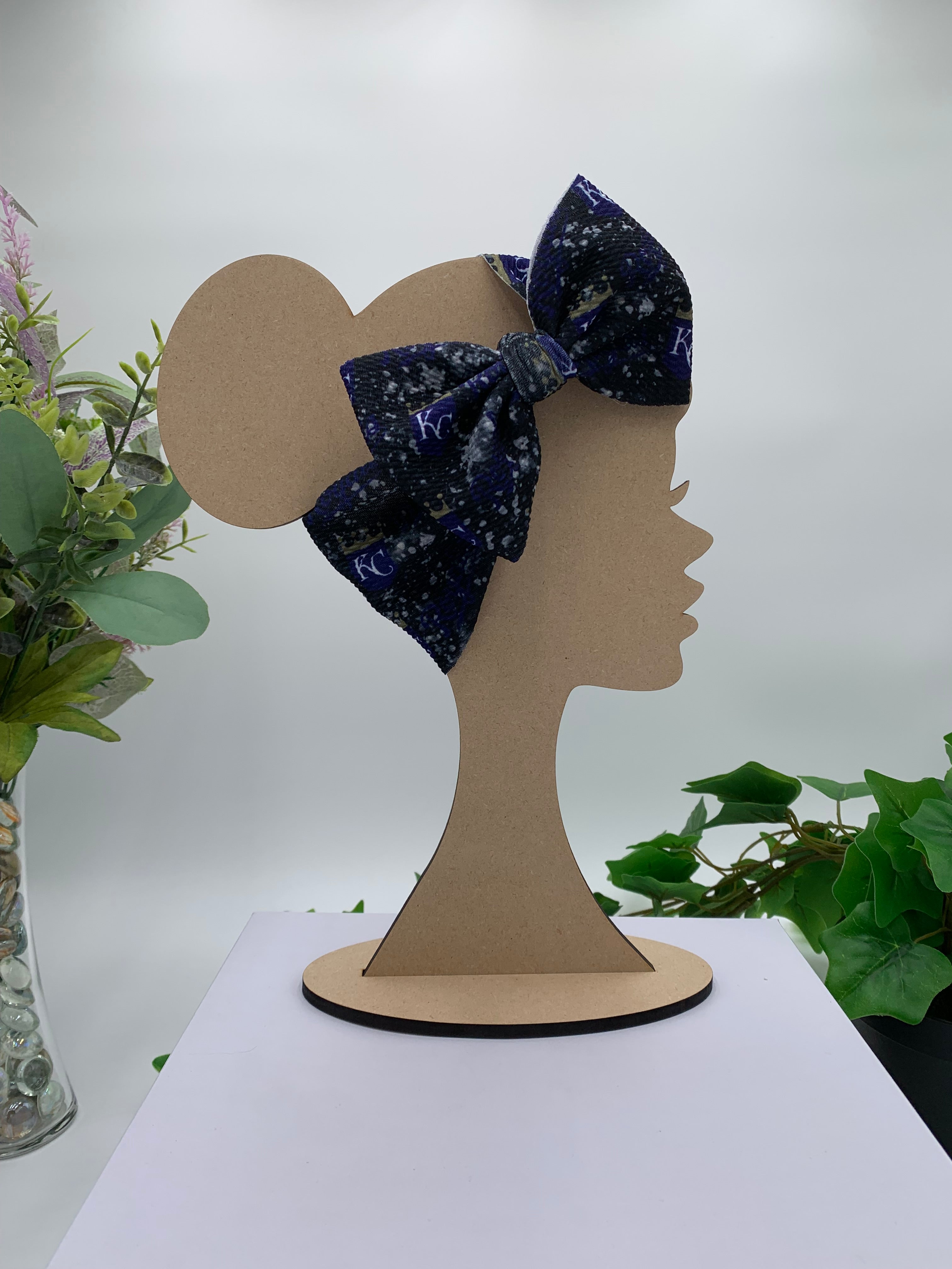 Colorful Navy blue constellation big bow headband on a mannequin head with a white background and greenery 