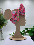 Hot Pink Easter themed big bow headband on a mannequin head with a white background and greenery 