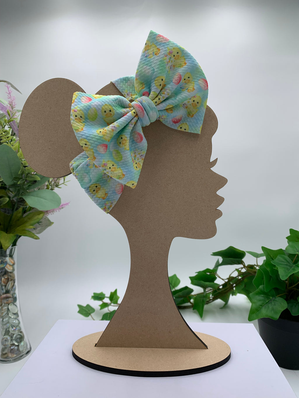 Rubber Duck themed big bow headband on a mannequin head with a white background and greenery 