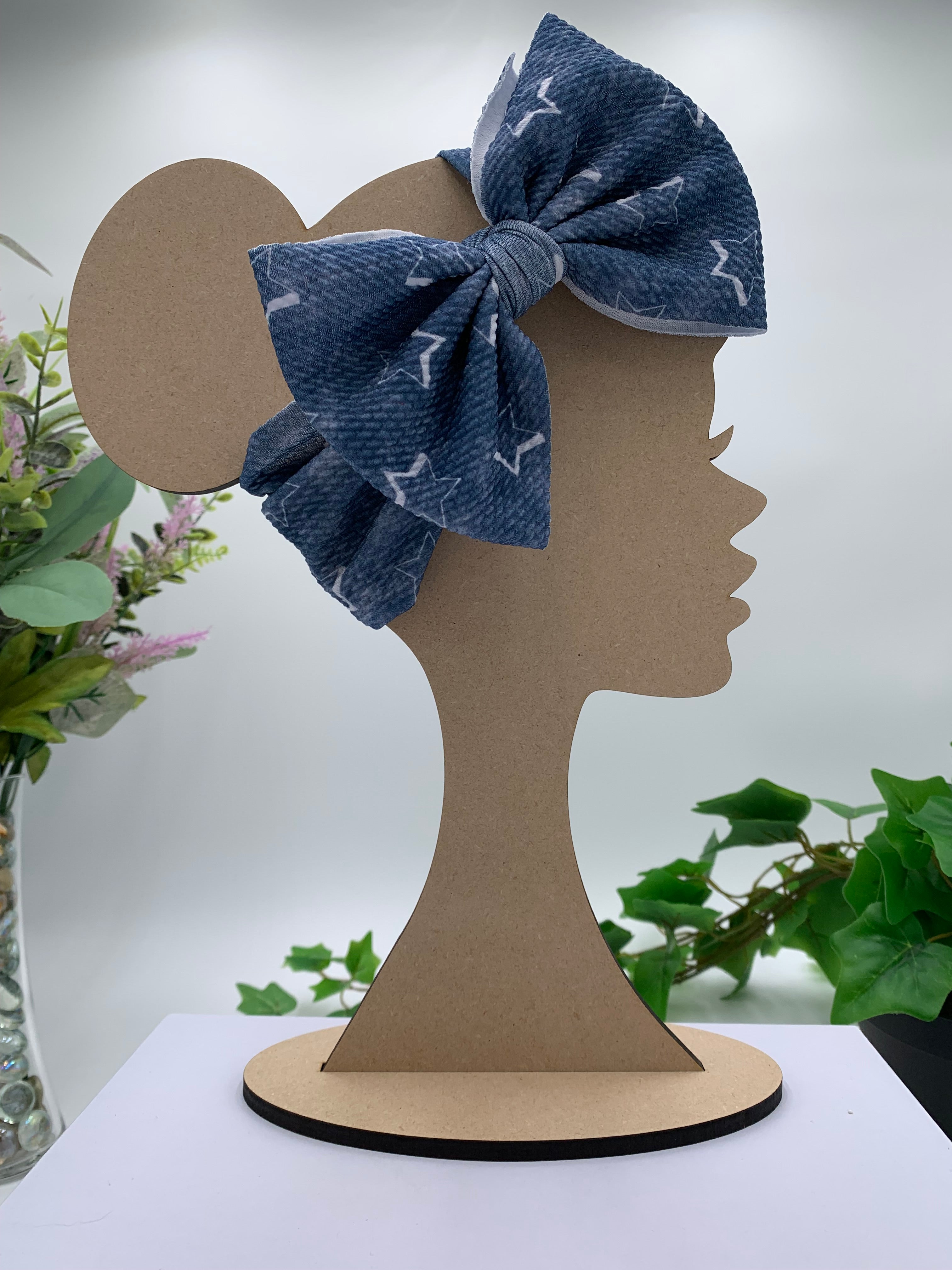 Blue with White starts themed big bow headband on a mannequin head with a white background and greenery 