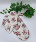 Floral baby sleeper sack with matching beanie on a white background with green leaves.