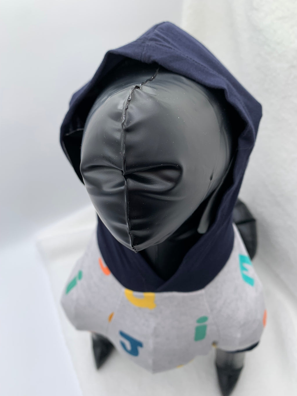 close up of Black dog mannequin with Gray alphabet pattern hoodie with navy blue hoodie up on a white background 