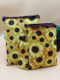 Quilted sunflower pattern with brown lace tablet and kindle/book sleeve with a fabric sunflower bookmark on a tan background with a potted green plant