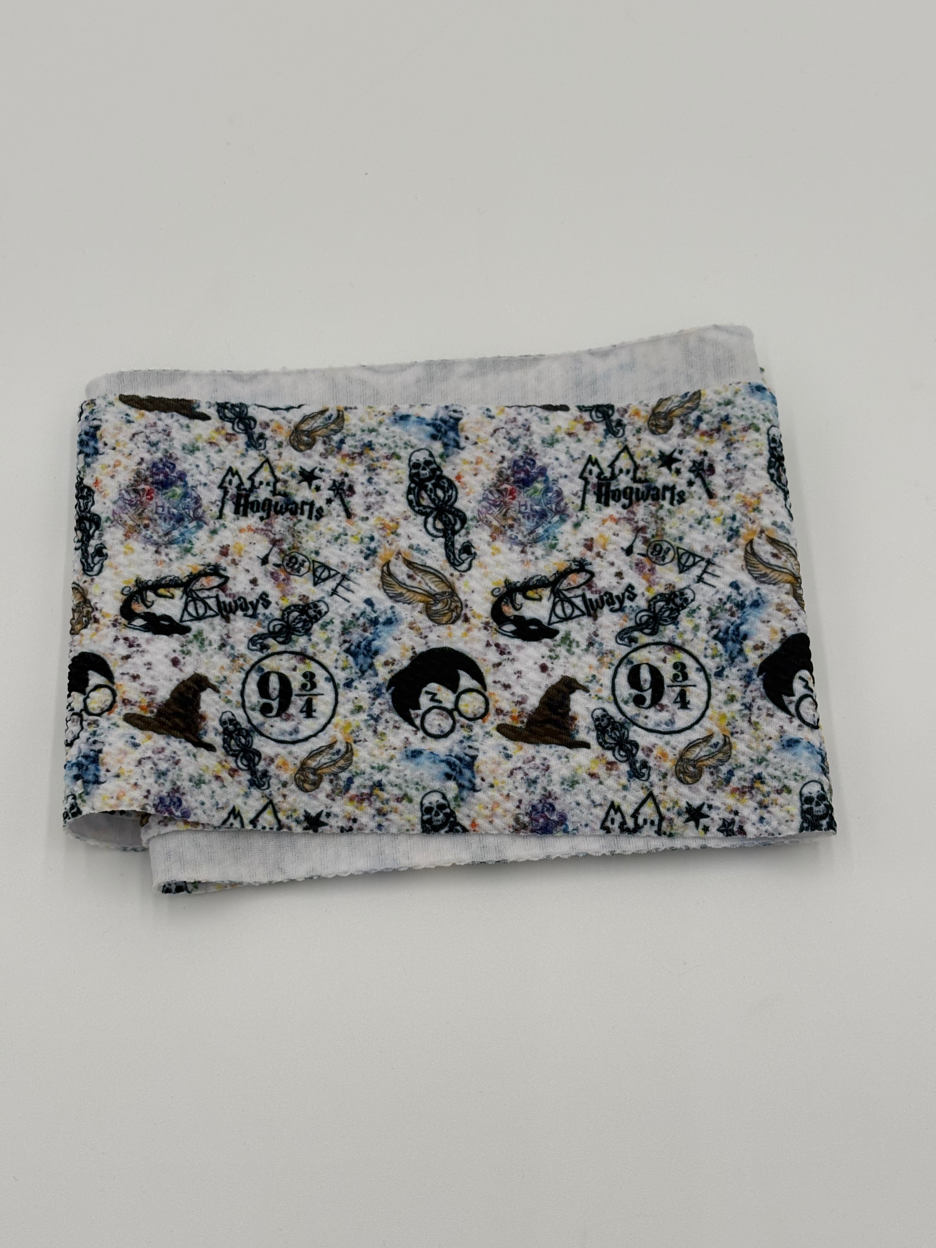 Folded fabric with wizard theme pattern on a white background