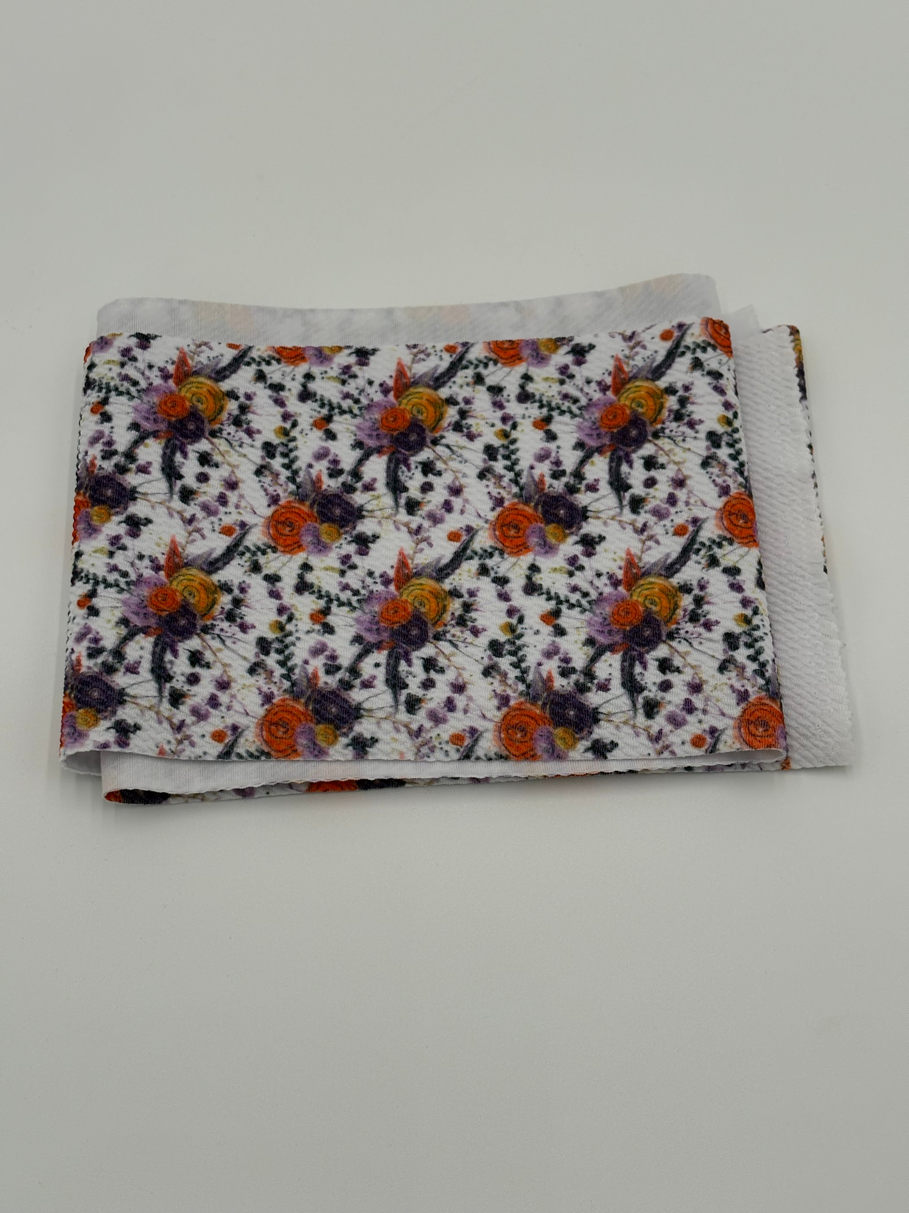 Folded fabric with Autumn flowers pattern on a white background
