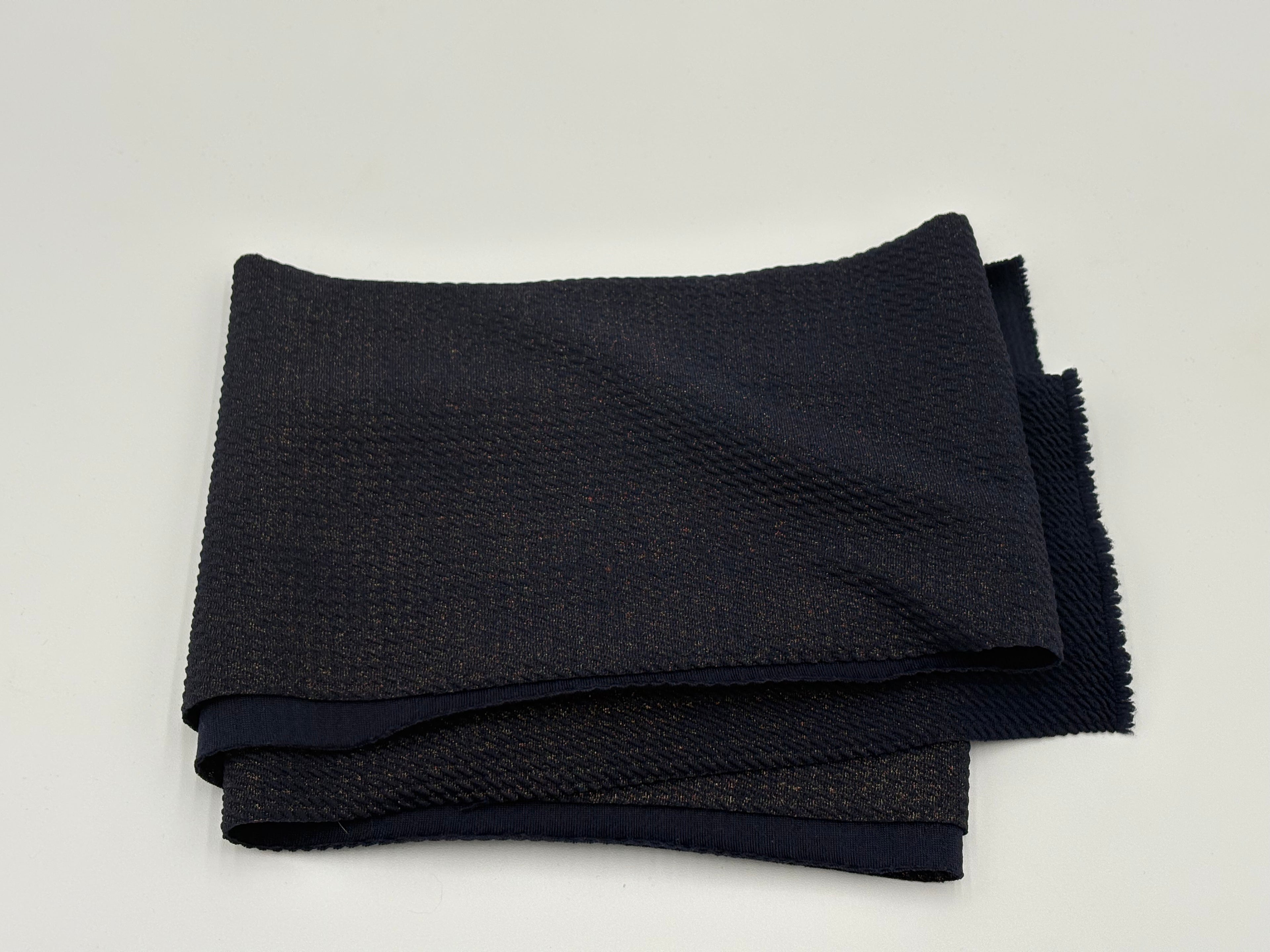 Folded fabric with navy blue with gold glitter on a white background
